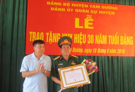 Đồng chí Hoàng Hoàng Thọ Trung, Bí thư Huyện ủy, trao Huy hiệu 30 năm tuổi Đảng cho đồng chí Nguyễn Thế Dương