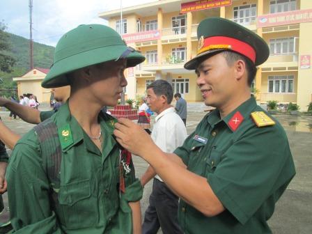 Cán bộ Ban CHQS huyện Tam Đường giúp tân binh chỉnh đốn trang phục chuẩn bị vào buổi lễ giao nhận quân (ảnh: TH)
