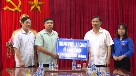 Đồng chí Vương Văn Thắng - UVBTV Tỉnh ủy, Bí thư Thành ủy thành phố Lai Châu trao số tiền trợ giúp cho huyện Tam Đường