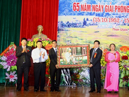 Đồng chí Nguyễn Khắc Chử - Bí thư Tỉnh ủy tặng bức ảnh Bác Hồ ngồi làm việc cho huyện Than Uyên