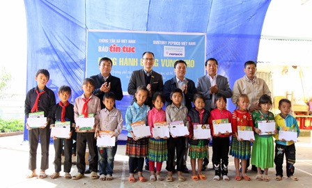 Đại diện lãnh đạo Báo Tin tức, Cơ quan thường trú Thông tấn xã Việt Nam tại Lai Châu, UBND huyện, Phòng Giáo dục huyện Tân Uyên tặng quà cho học sinh