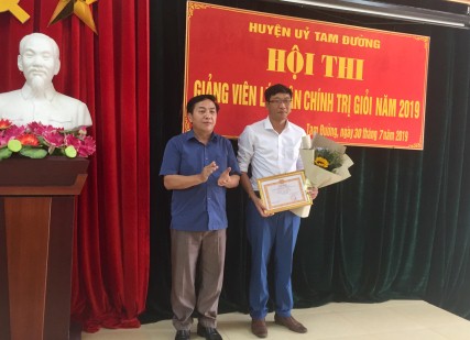 Đồng chí Sùng Lử Páo-Phó BT Thường trực Huyện ủy, Trưởng BTC Hội thi trao giải thưởng cho giảng viên đạt giải Nhất