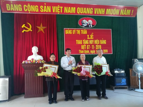 Lãnh đạo Đảng ủy thị trấn trao huy hiệu Đảng cho các đảng viên