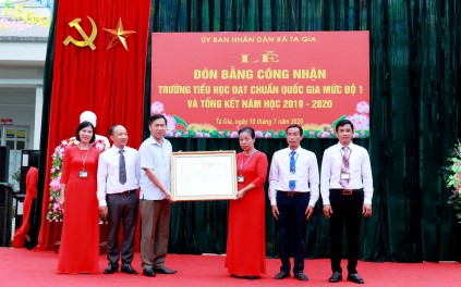 Thừa ủy quyền của Chủ tịch UBND tỉnh, Đồng chí Trần Quang Chiến - Phó Chủ tịch UBND huyện trao bằng công nhận đạt chuẩn quốc gia cho ban giám hiệu trường tiểu học xã Ta Gia