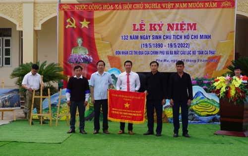 Đồng chí Trần Quang Chiến - Phó Chủ tịch UBND huyện Than Uyên trao Cờ thi đua của Thủ tướng Chính phủ cho Nhân dân và cán bộ xã Pha Mu, huyện Than Uyên