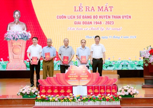 Đồng chí Nguyễn Văn Thăng - Phó Bí thư Huyện ủy, Chủ tịch UBND huyện Than Uyên tặng cuốn Lịch sử Đảng bộ huyện cho các đại biểu