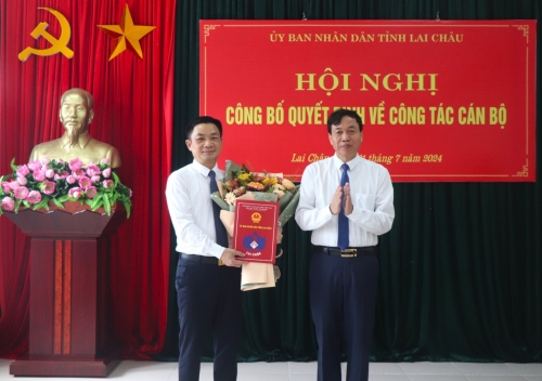 Đồng chí Lê Văn Lương - Phó Bí thư Tỉnh uỷ, Chủ tịch UBND tỉnh trao Quyết định và tặng hoa chúc mừng đồng chí Lò Việt Tuyển