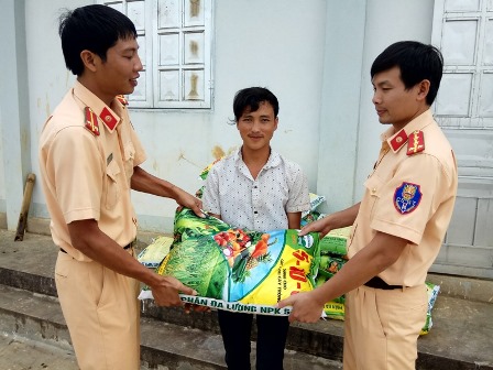 Cán bộ, chiến sỹ đội CSGT Công an huyện Tam Đường trao phân bón hỗ trợ cho người dân