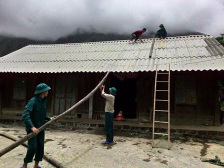 Dân quân xã Sơn Bình (huyện Tam Đường) giúp Nhân dân lợp lại mái nhà