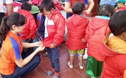 Các thành viên Nhóm cháo từ thiện trao áo ấm cho các em học sinh Trường Tiểu học Xà Dề Phìn.