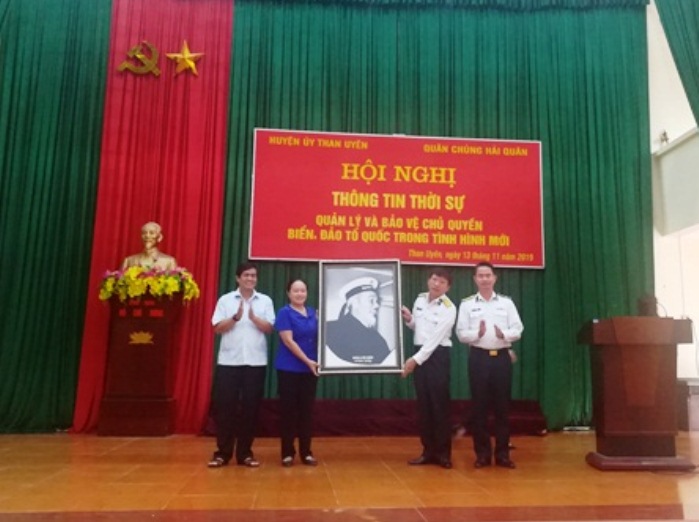 Đại diện Bộ tham mưu Quân chủng Hải quân tặng bức tranh Bác Hồ đội mũ Hải quân quà cho Đảng bộ, chính quyền, Nhân dân các dân tộc trong huyện