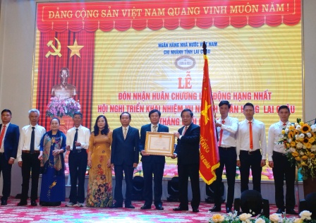 Đ/c Nguyễn Kim Anh - UV Ban cán sự Đảng, Phó Thống đốc NHNN Việt Nam thừa ủy quyền của Chủ tịch nước trao tặng Huân chương lao động hạng Nhất cho NHNN chi nhánh Lai Châu