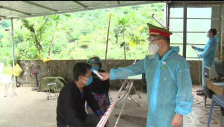 Lực lượng tại chốt kiểm dịch xã Mường Kim huyện Than Uyên đo thân nhiệt cho người dân vào địa bàn