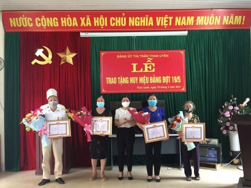 Đồng chí Trần Thị Sâm - UVBTV, Trưởng Ban Tuyên giáo Huyện ủy trao Huy hiệu cho các đồng chí đảng viên