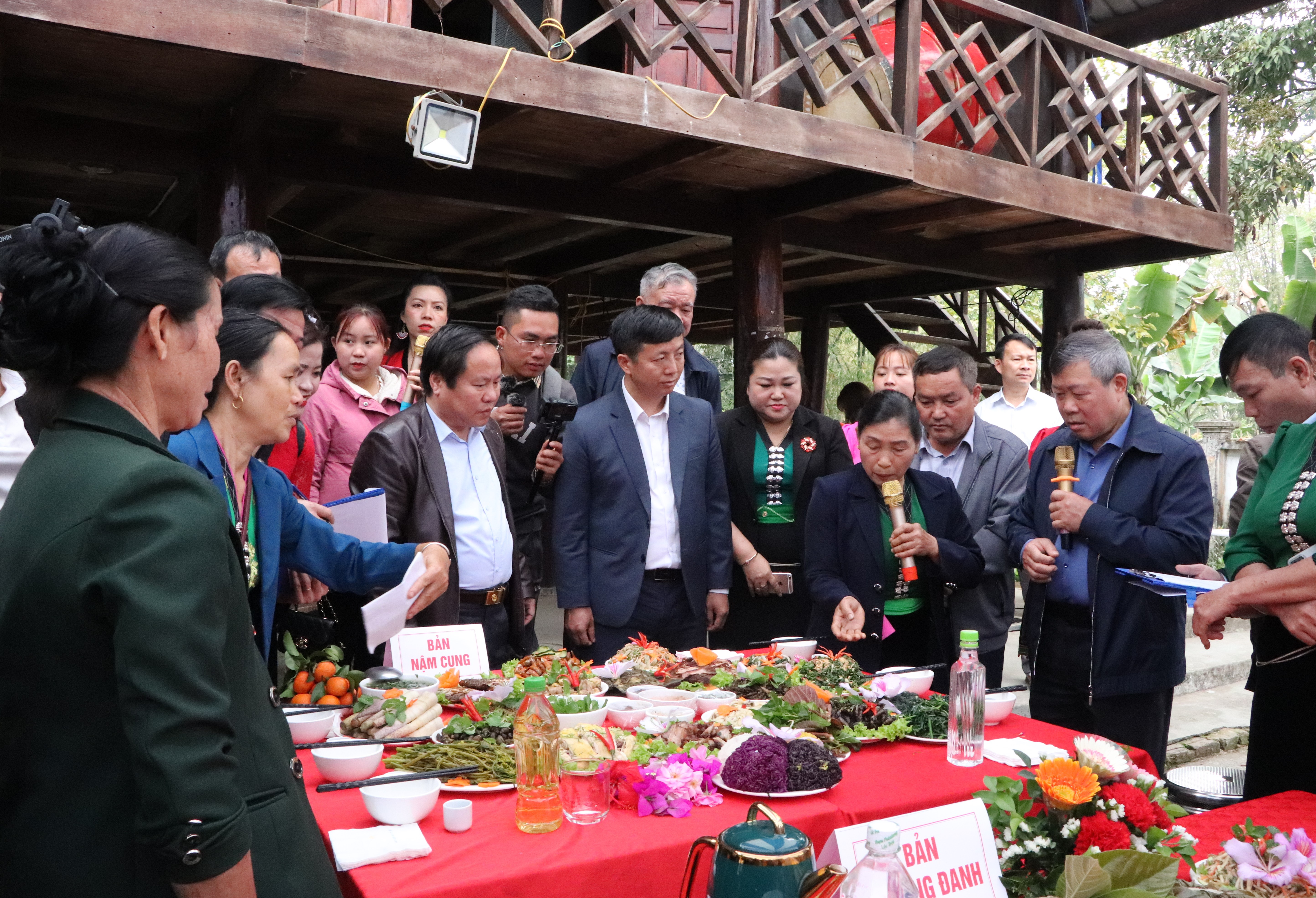 Các đồng chí lãnh đạo tỉnh, huyện Phong Thổ nghe đại diện bản Nậm Cung (xã Mường So) giới thiệu về các món ăn dự thi tại lễ hội Nàng Han