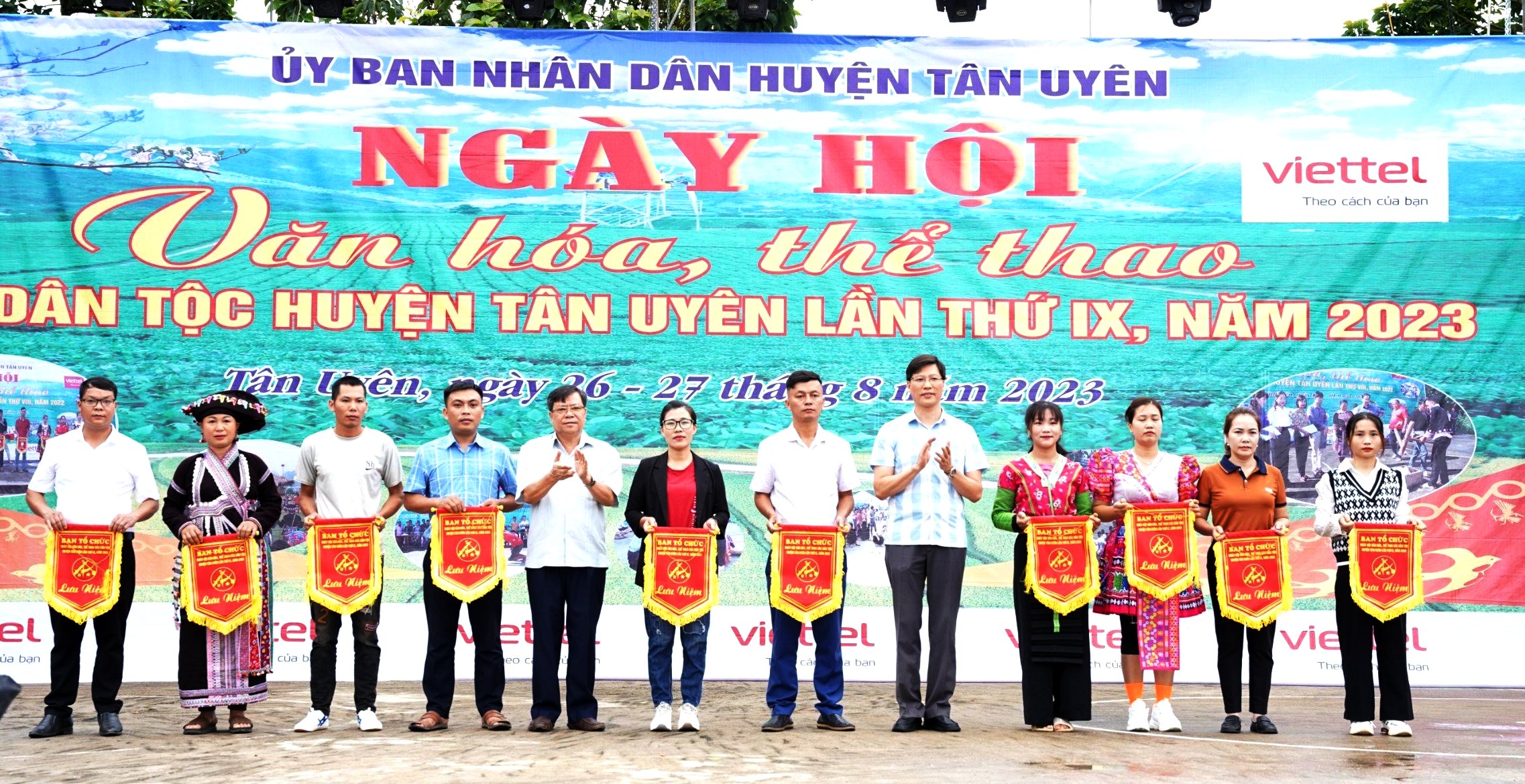 Các đồng chí lãnh đạo huyện Tân Uyên trao cờ lưu niệm cho các đội tham thi tham gia Ngày hội
