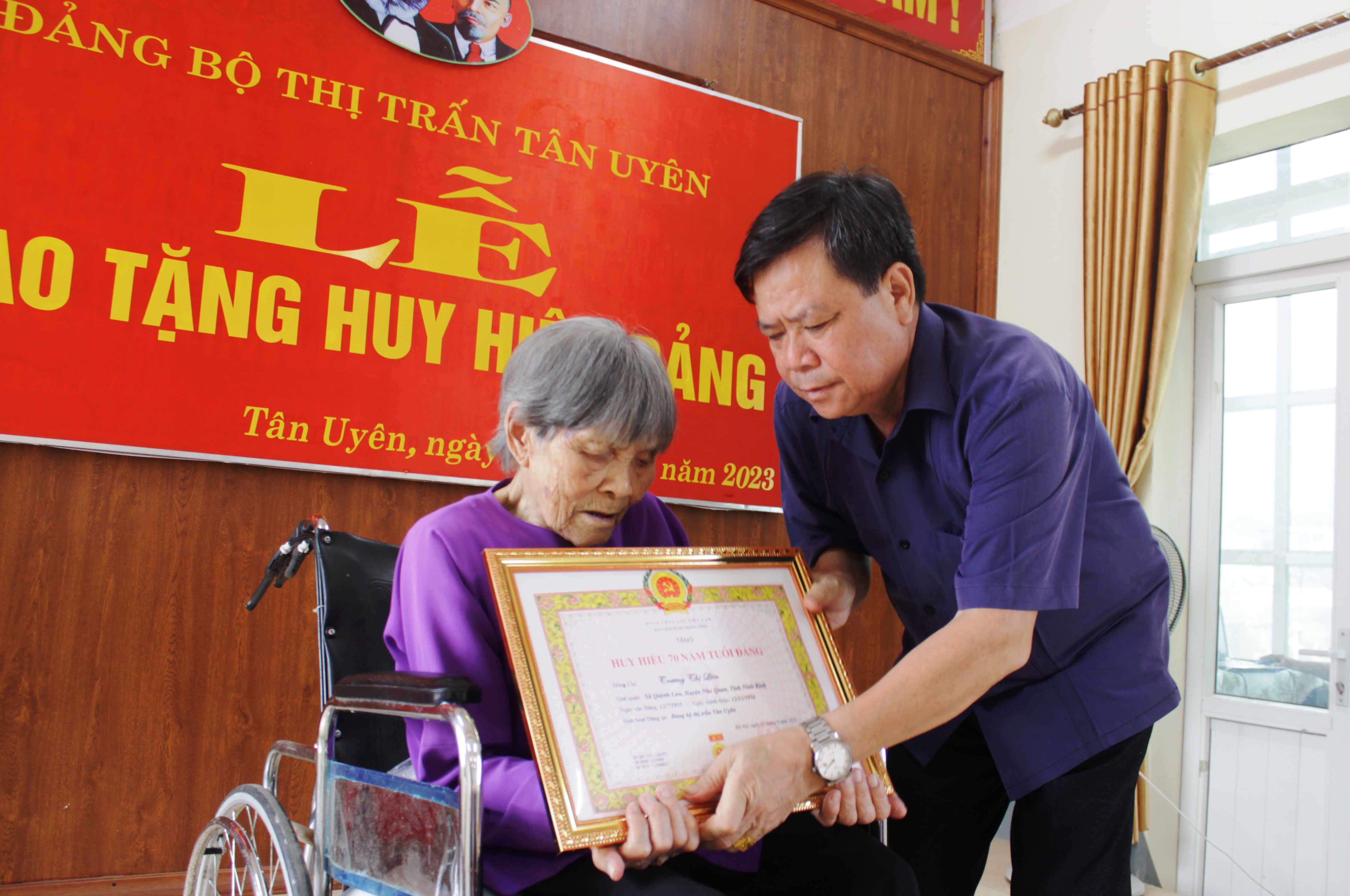 Đồng chí Phan Văn Nguyên - Phó Bí thư Thường trực Huyện ủy trao Huy hiệu 70 năm tuổi Đảng cho cụ Trương Thị Liên
