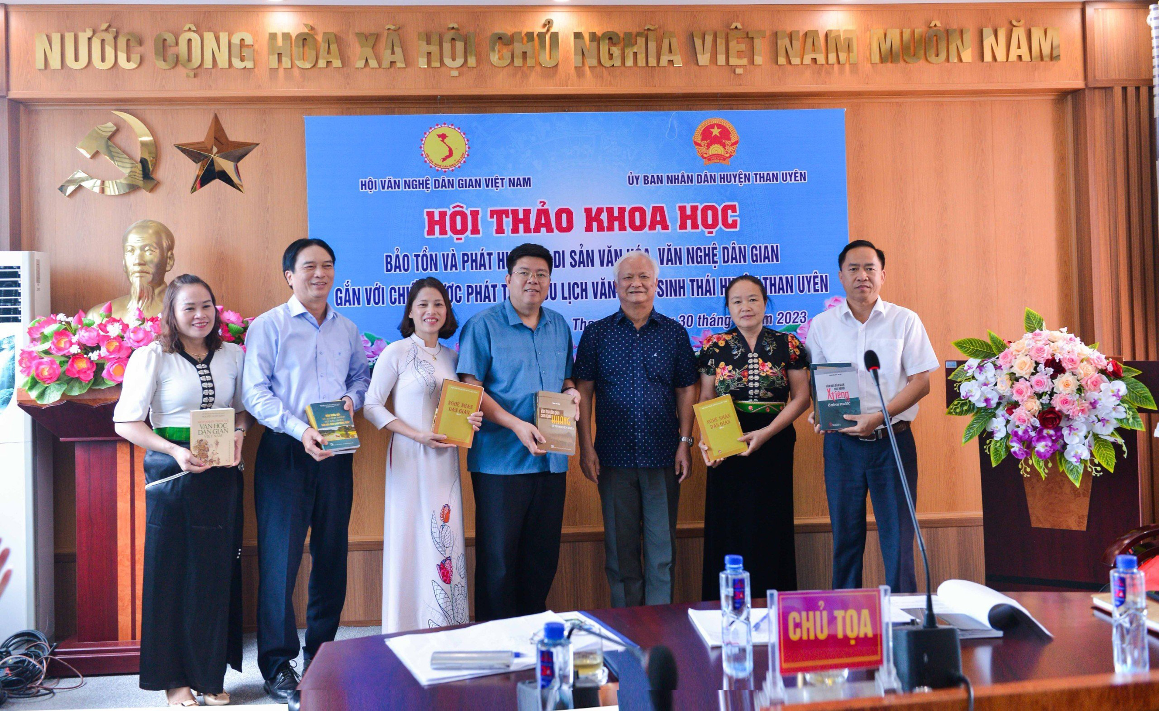 Lãnh đạo Hội Văn nghệ dân gian Việt Nam tặng những cuốn sách do Hội nghiên cứu, sưu tầm cho lãnh đạo huyện Than Uyên