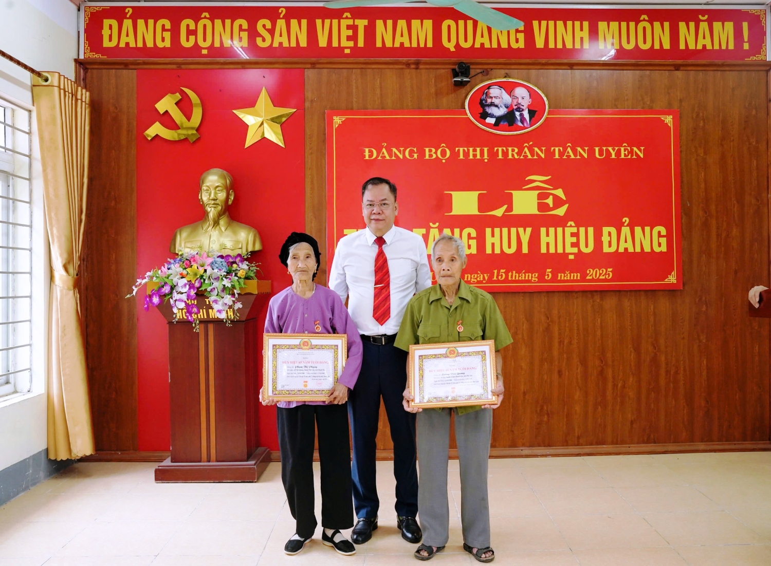 Đồng chí Dương Đình Đức - Tỉnh ủy viên, Bí thư Huyện ủy trao Huy hiệu 65 năm tuổi Đảng cho đảng viên Phạm Thị Phụng