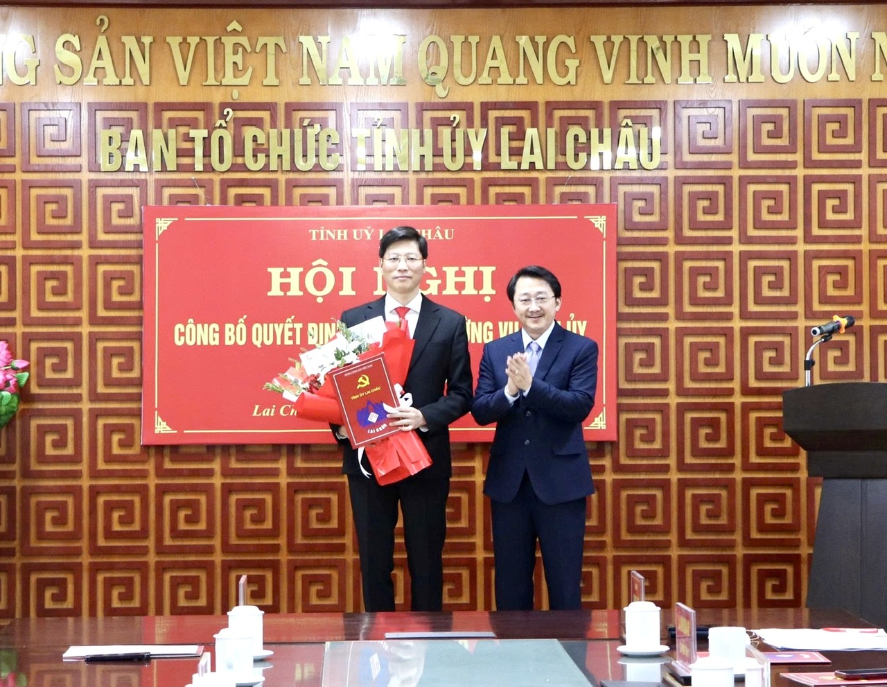 Đồng chí Sùng A Hồ - Phó Bí thư Thường trực Tỉnh ủy trao Quyết định và tặng hoa chúc mừng đồng chí Bùi Huy Phương
