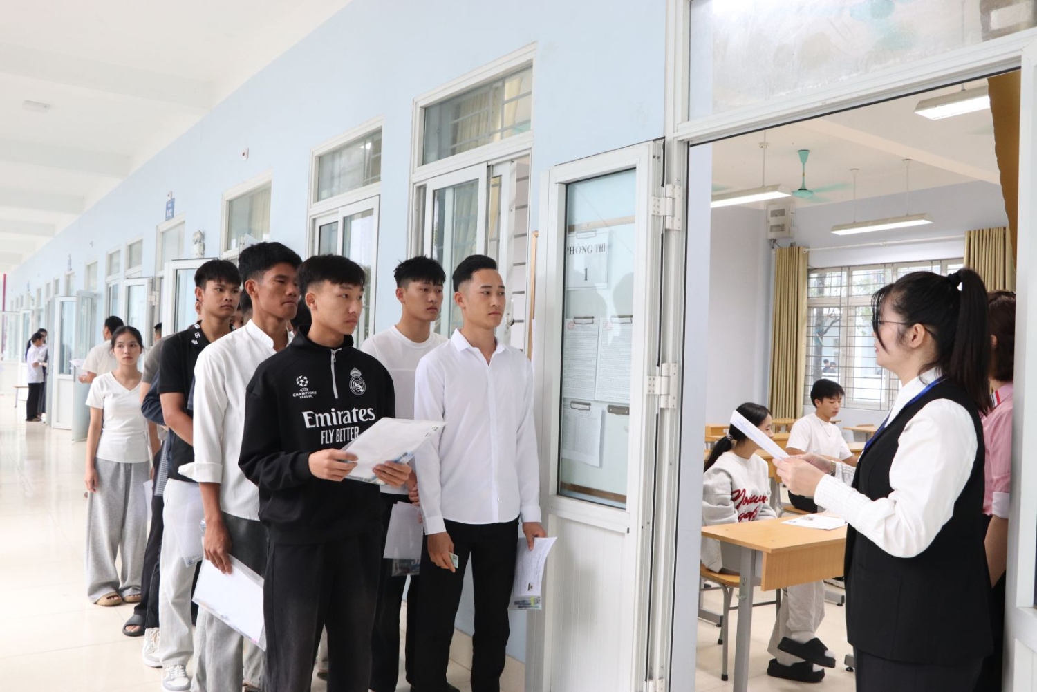 Các thí sinh xếp hàng chuẩn bị làm thủ tục vào phòng thi