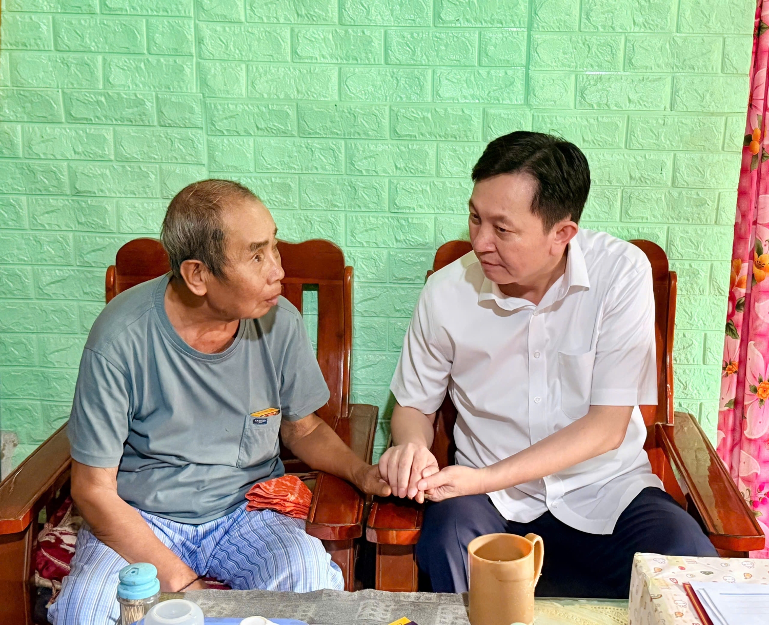 Đồng chí Lò Văn Cương - Ủy viên Ban Thường vụ Tỉnh uỷ, Chủ nhiệm Ủy ban Kiểm tra Tỉnh uỷ ân cần hỏi thăm sức khỏe ông Lò Văn Phên, Thôn 1, xã Bum Tở (thương binh 31%)